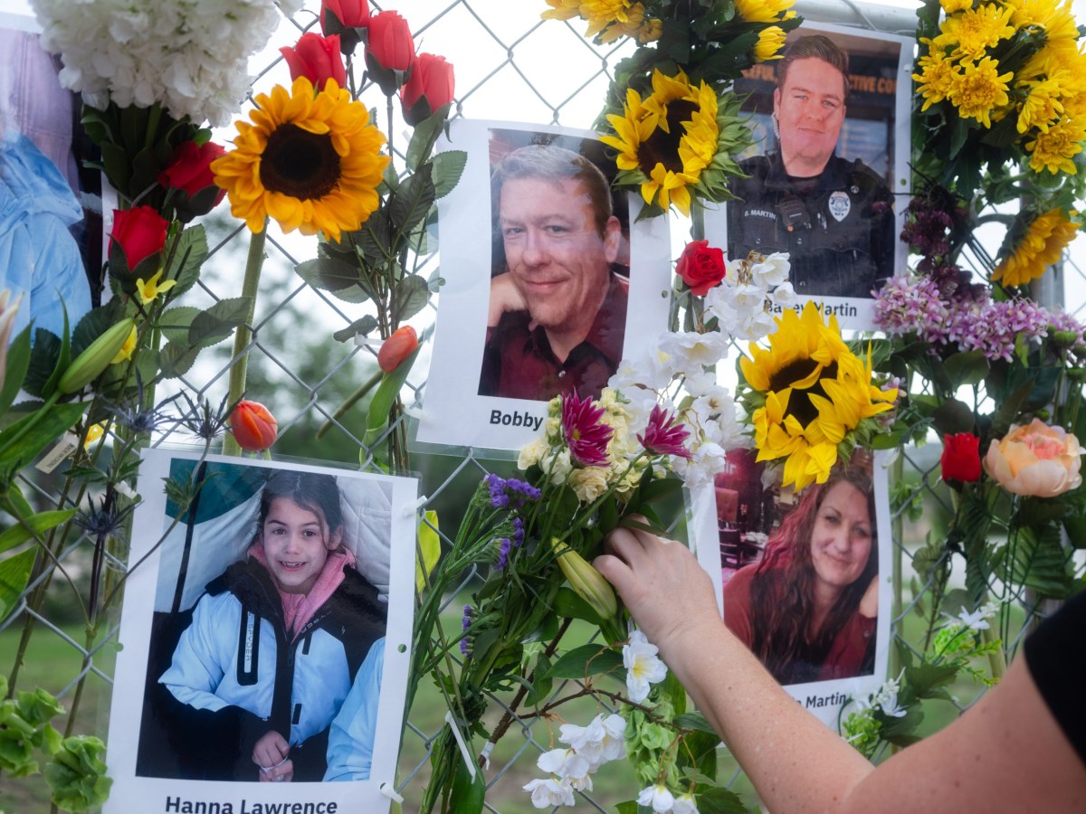 Community members add flowers to a memorial on July 9 honoring victims of the flood in Kerrville.