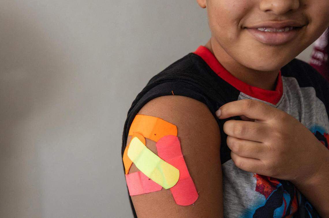 Omar Wahidi, 12, shows bandages from vaccines given to him in his right arm on August 13, 2025.