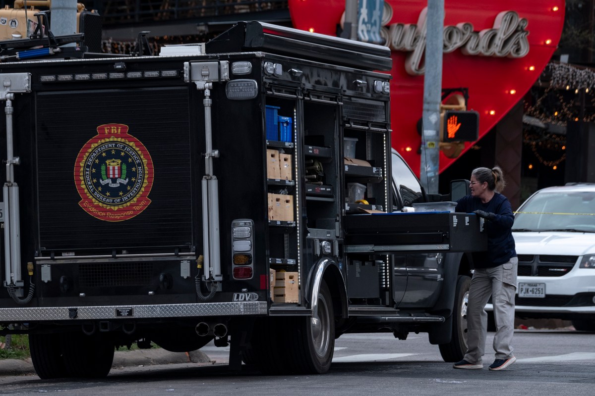 FBI personnel collect evidence at the scene of a fatal shooting that left three dead, including the suspected shooter, and wounded at least 14 in downtown Austin on Sunday.