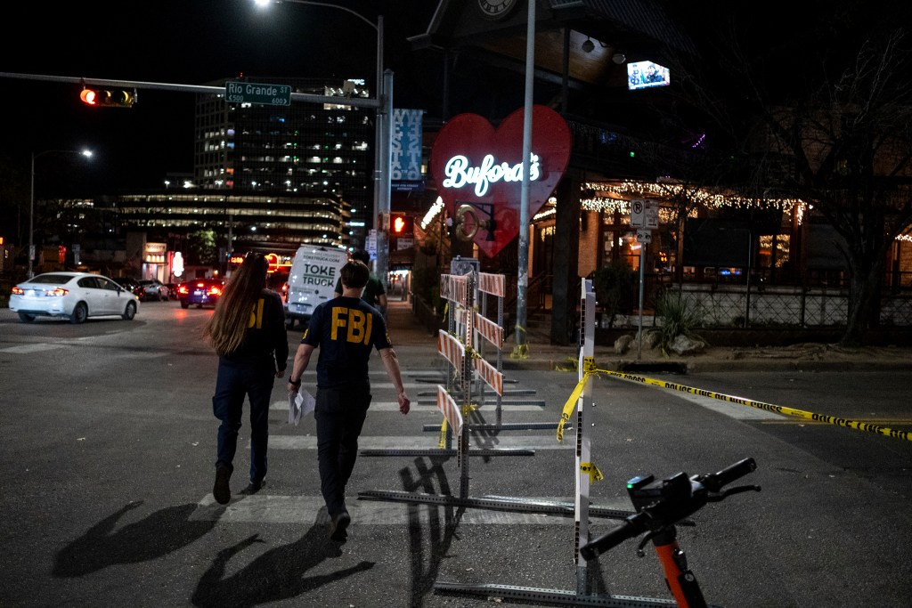 FBI personnel walk toward the scene of a fatal shooting that left three dead, including the suspected shooter, and wounded at least 14 others, in downtown Austin on March 1, 2026.