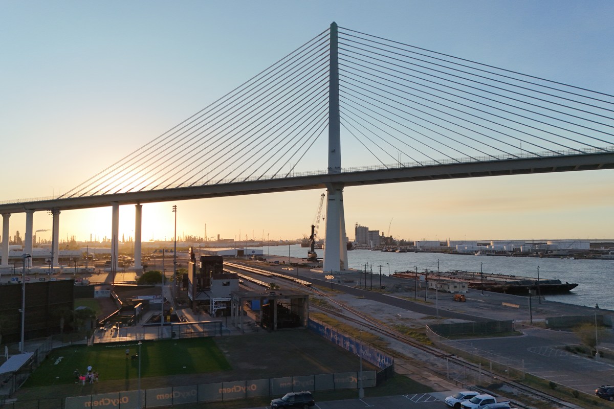 The New Harbor Bridge in Corpus Christi is shown just before sunset, with industrial development in the background, on March 19, 2026.