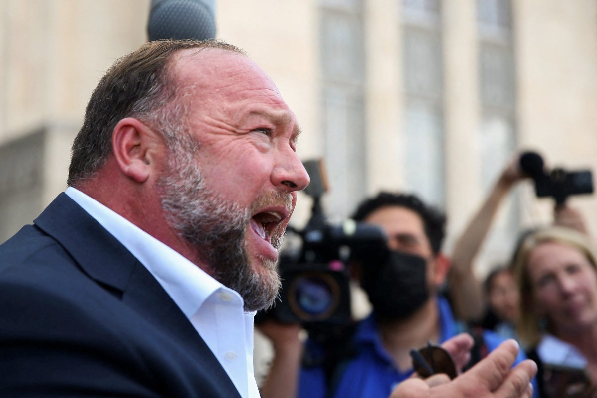 Alex Jones speaks with the media Tuesday following the end of that day’s testimony in his defamation trial in Austin.