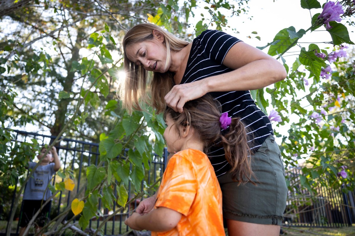 Independent voter Brienne Reverendo fixes her daughter’s hair outside of their Pearland home on Sunday