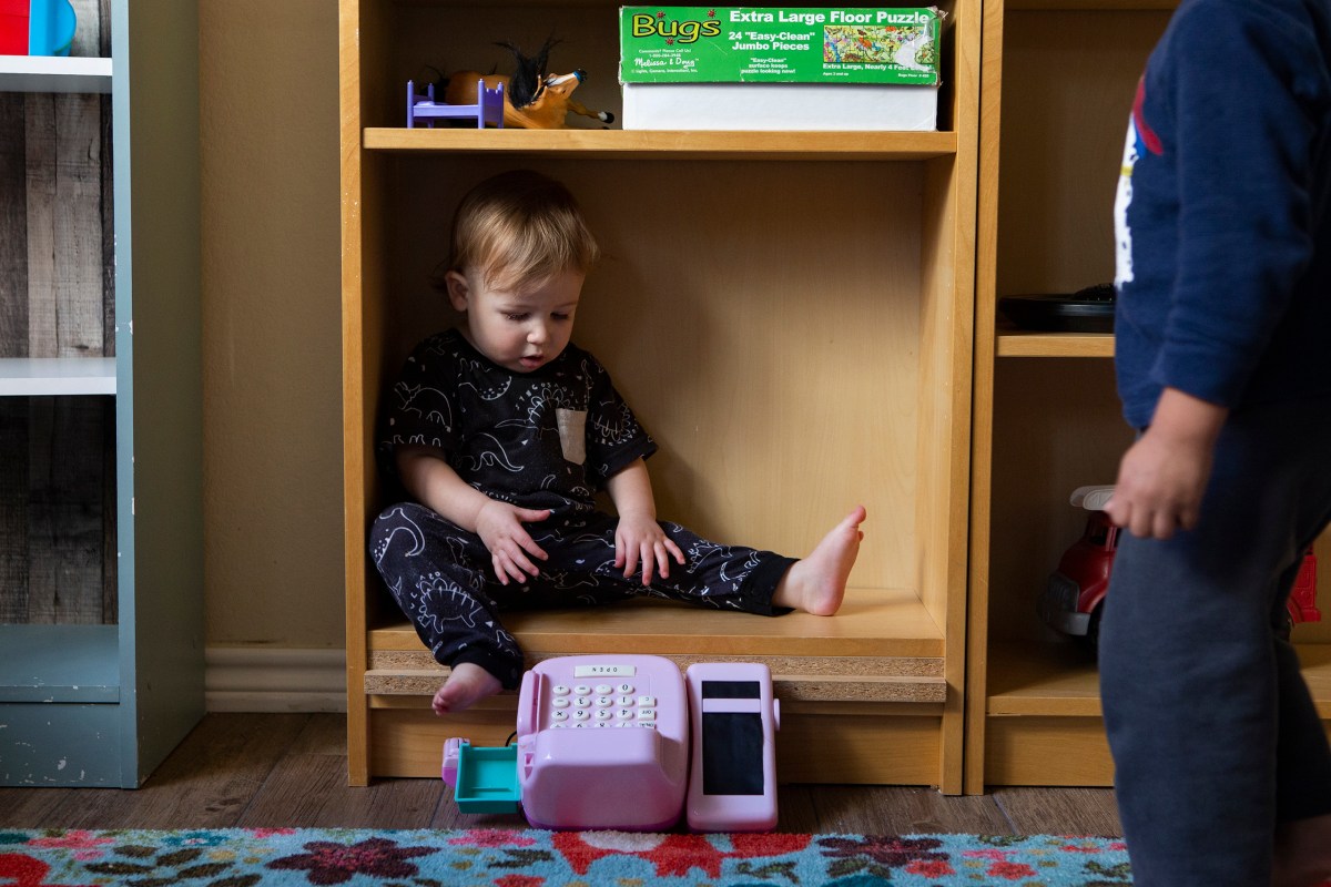 A child sits in a bookshelf at Kid's Castle Family Daycare and Preschool in Pflugerville in 2022.