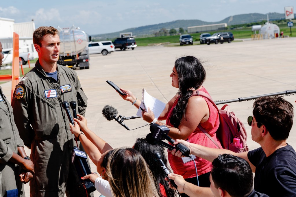 Texas Tribune Fellow Atirikta Kumar asks a question to US Coast Guard Pilot Ian Hopper at the Kerr County Airport in Kerrville on Friday July 11, 2025.