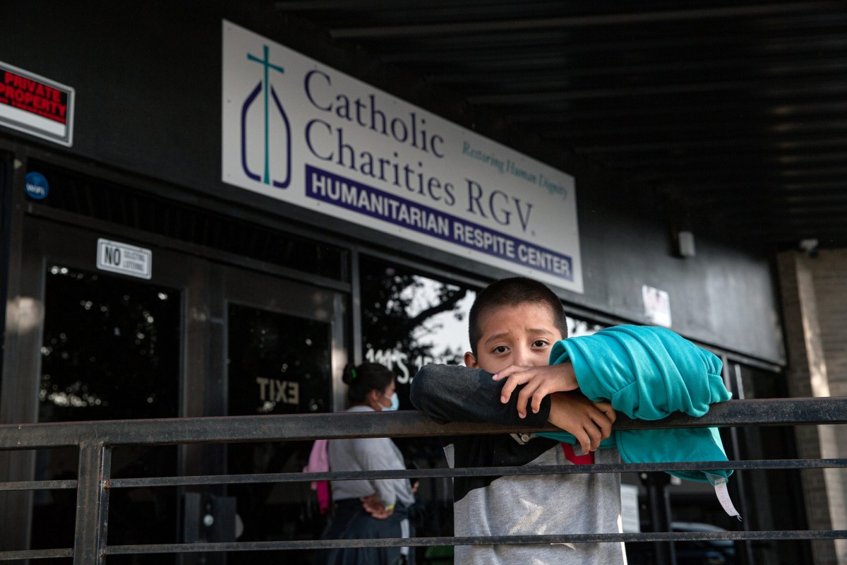 A migrant child waits with his family in front of the Catholic Charities RGV Humanitarian Respite Center in McAllen on July 27, 2021.