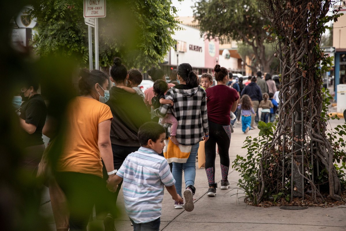 Migrants walk from a Department of Homeland Security tent facility in front of the McAllen bus station to Catholic Charities RGV Humanitarian Respite Center on April 22, 2021.